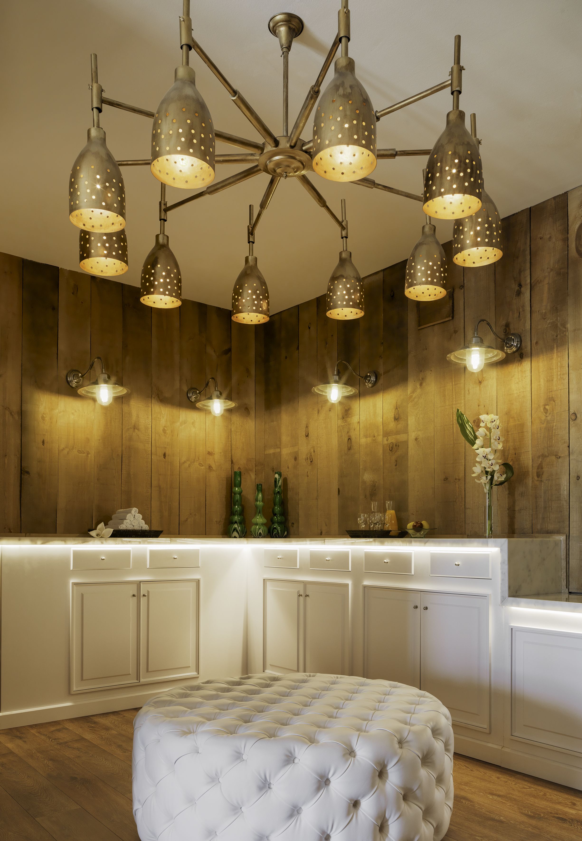 A modern kitchen with a central island, pendant lighting, and wooden paneling.