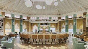 Een ruime, goed verlichte ruimte met een hoge plafond en grote ramen, met een centraal gelegen bar met krukken en diverse zitmogelijkheden.