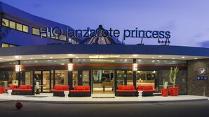 Het uiterlijk van het Lanzarote Princess hotel met een modern ontwerp, met een opvallend bord, een terras en een goed zicht op de ingang.