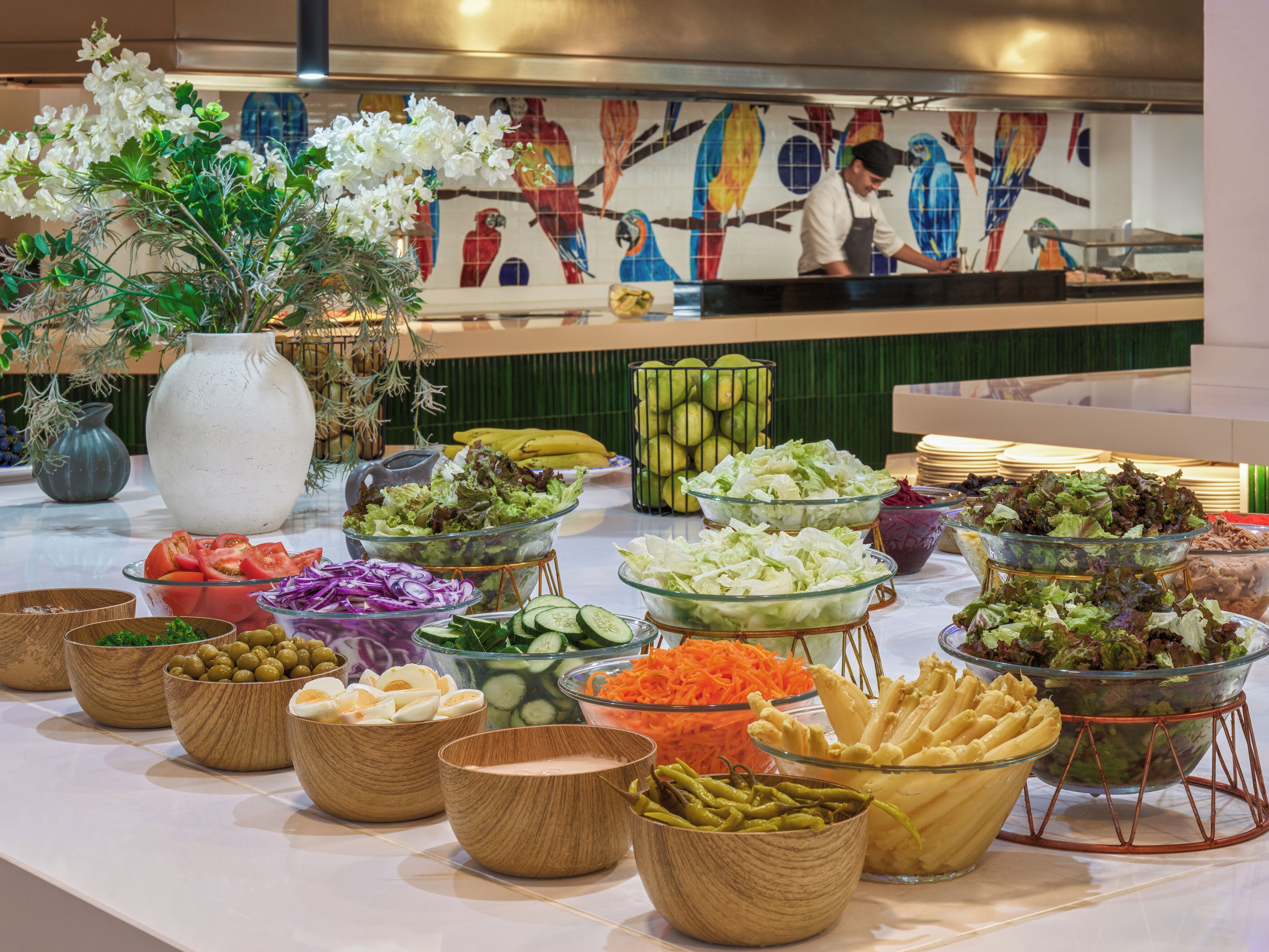A buffet table with various food items and a decorative vase.