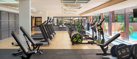 A gym with treadmills, elliptical machines, and weight benches.