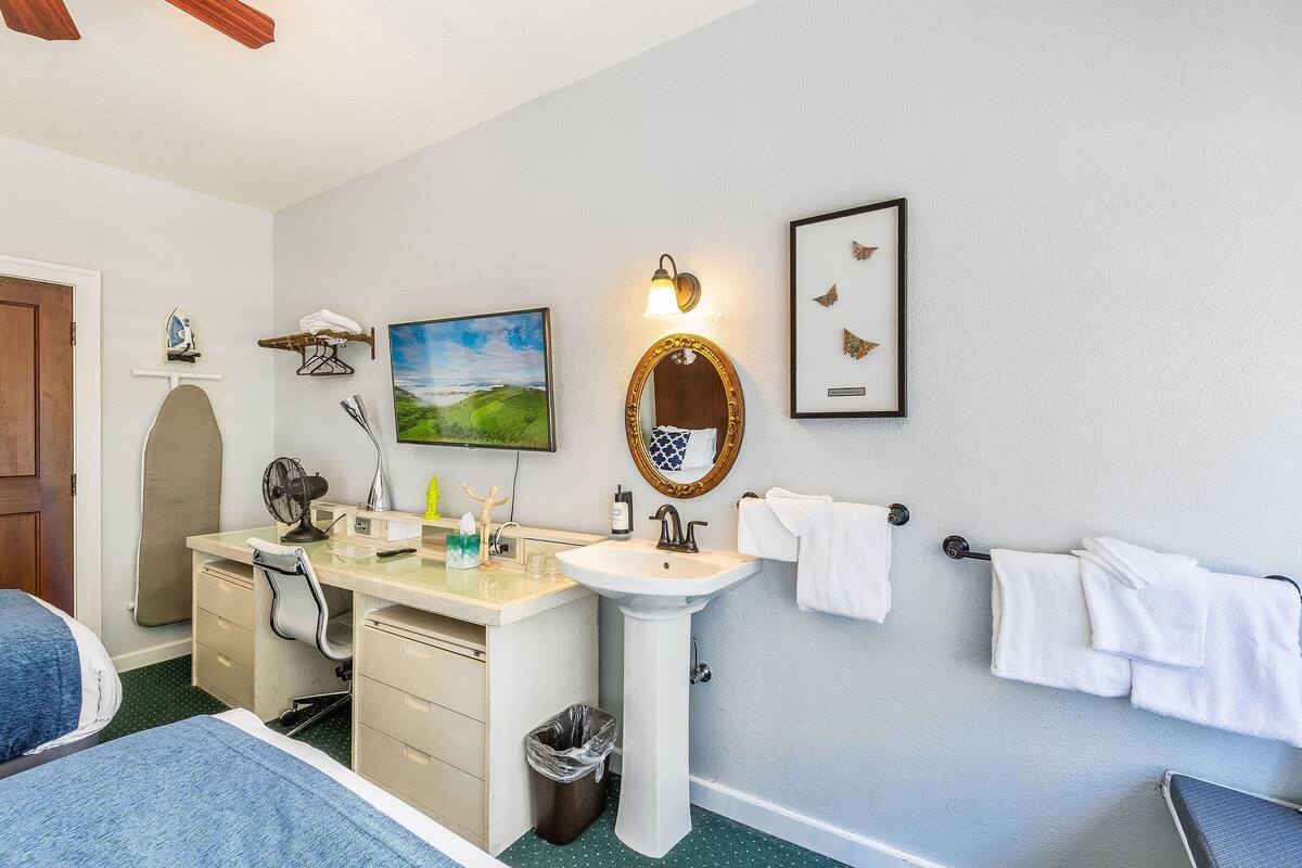 A bathroom with a sink, mirror, and towel rack.