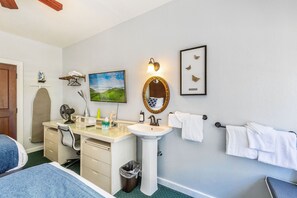 A bathroom with a sink, mirror, and towel rack.