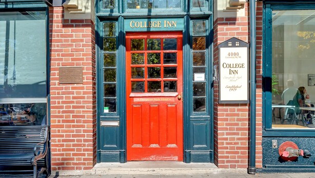 Una puerta roja con un letrero que dice "College Inn" en la parte superior.