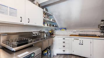Una cucina moderna con mobili bianchi, elettrodomestici in acciaio inossidabile e un piano di lavoro in legno.