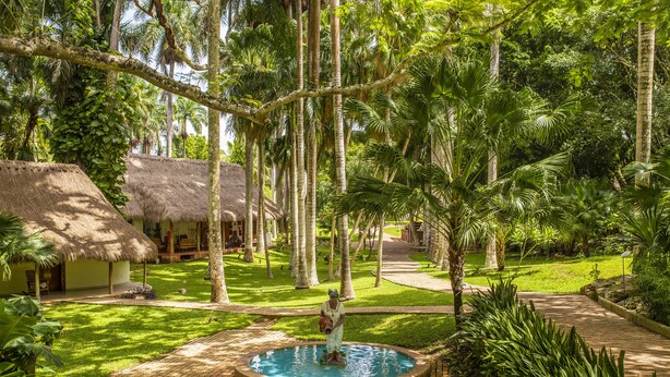 A tropical resort with thatched-roof huts, a central pool, and lush greenery. - Mayaland Hotel & Bungalows (Chichen Itza)