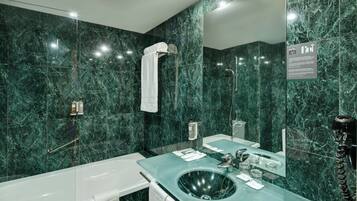 Een bad/douchecombinatie, een haardroger, een bidet, handdoeken
