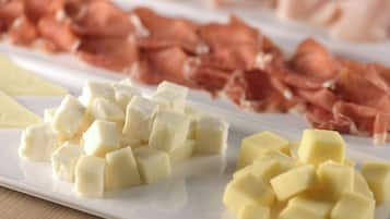 A plate with cubed cheese and sliced cured meat.