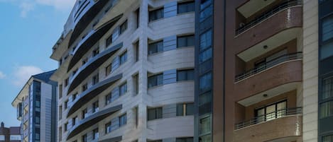 Un edificio residencial de varios pisos con balcones y ventanas amplias.