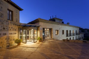 Un bâtiment en pierre avec une entrée en verre et une enseigne indiquant « De Joledo ».