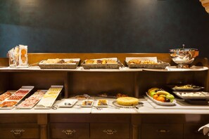 Un buffet proposant une variété de plats et d’ustensiles.