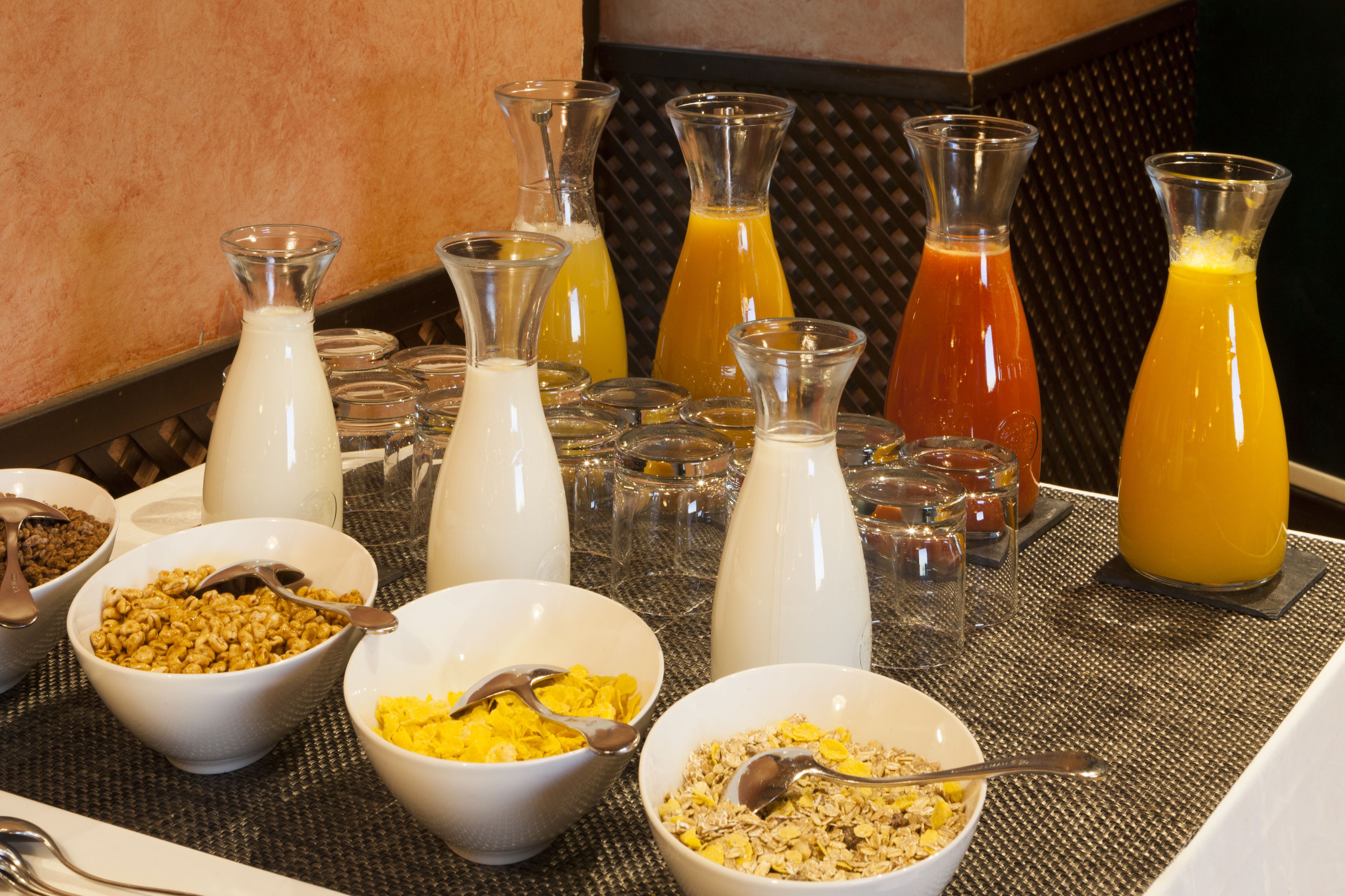 Un buffet de petit-déjeuner proposant un assortiment de céréales, de lait et de jus de fruits.
