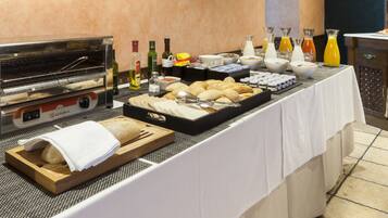 Montaje de bufé con horno tostador, pan, pasteles y diversas bebidas.