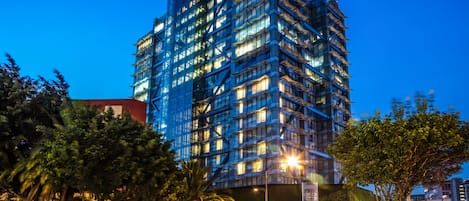 A modern high-rise hotel with multiple floors, large windows, and a prominent signage.