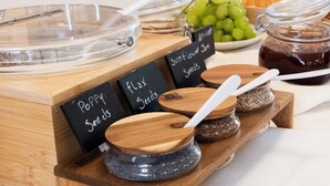 A buffet with various food items and containers labeled with names like 'Dried Apricots,' 'Raisins,' 'Sunflower Seeds,' and 'Poppy Seeds.' - Russo Palace Hotel (Venice)
