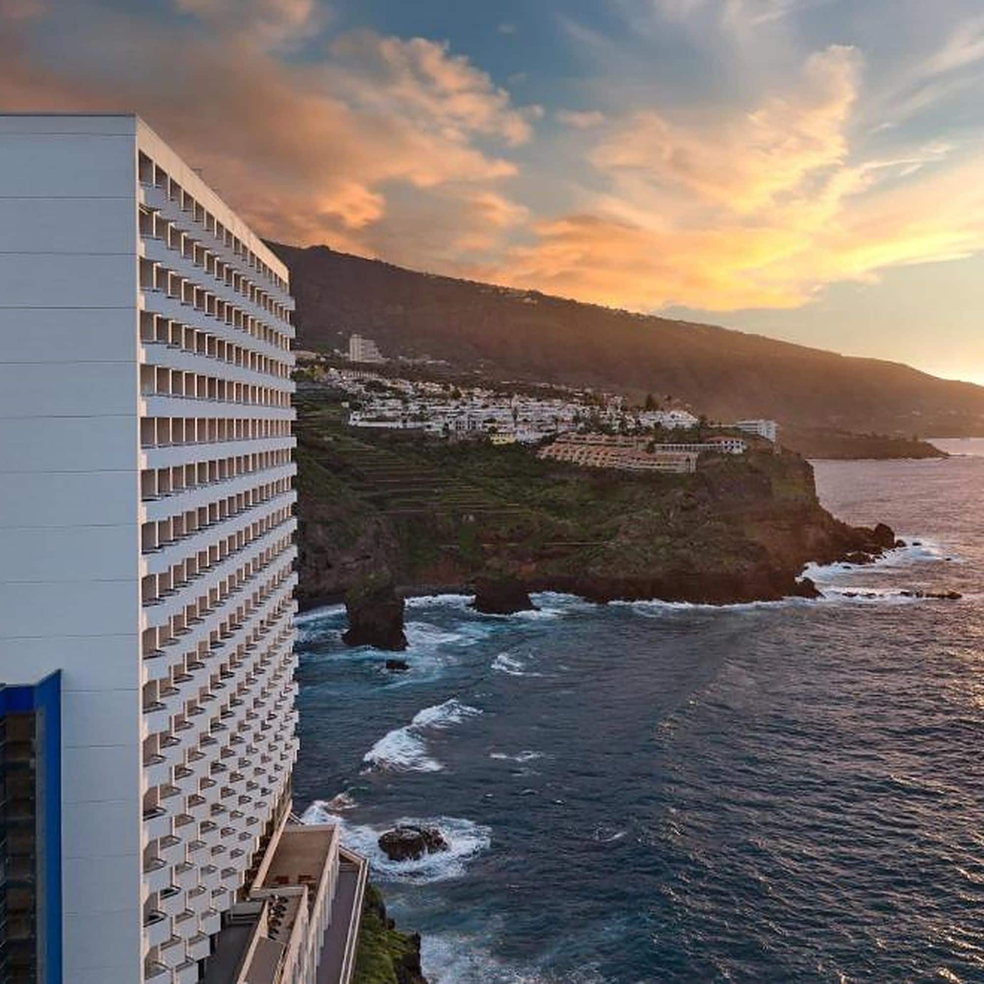 Un hotel frente al mar, con vistas al océano y a un pueblo en la ladera de una colina.