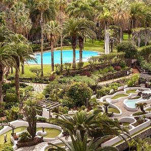 A resort with a central swimming pool, surrounded by palm trees and manicured gardens. - Precise Resort Tenerife (Los Realejos)