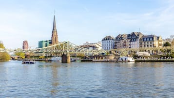 A river with a bridge, historic buildings, and a church spire.
