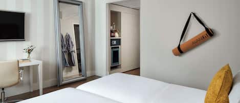 Een hotelkamer met een bed, bureau, televisie, kledingkast en een badkamer.