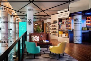 Un interior moderno con una zona de bar, estanterías y asientos.