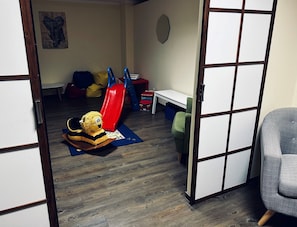 Relax in a serene space with a traditional shoji screen, a play area featuring a slide, bench, and cushioned seat.