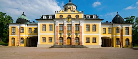 A large, yellow building with a central dome and symmetrical windows.