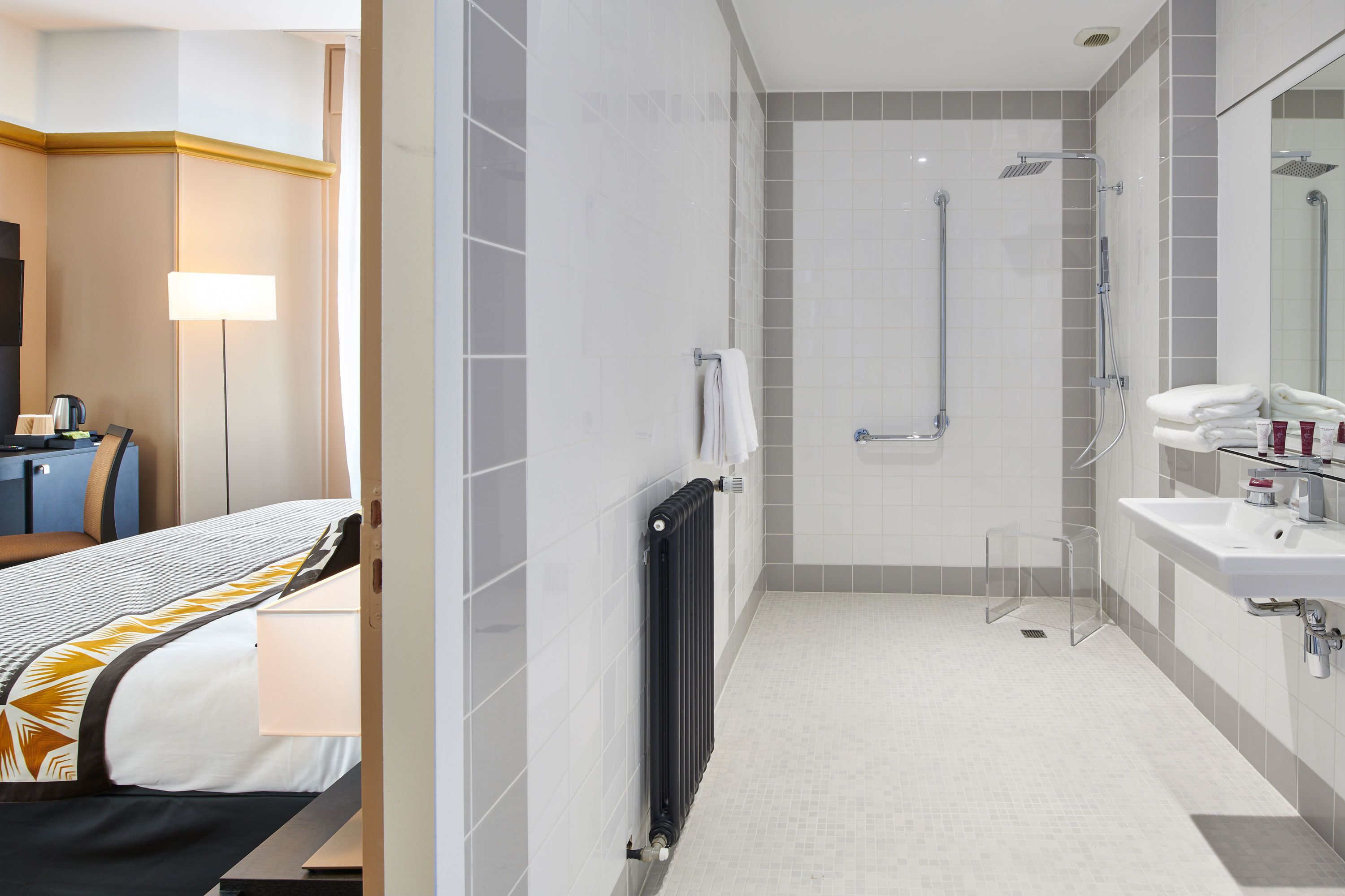 Un baño de hotel moderno con ducha, lavamanos e inodoro.