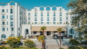 Un hôtel à plusieurs étages doté d’une cour intérieure, de sièges en plein air et d’un toit plat.