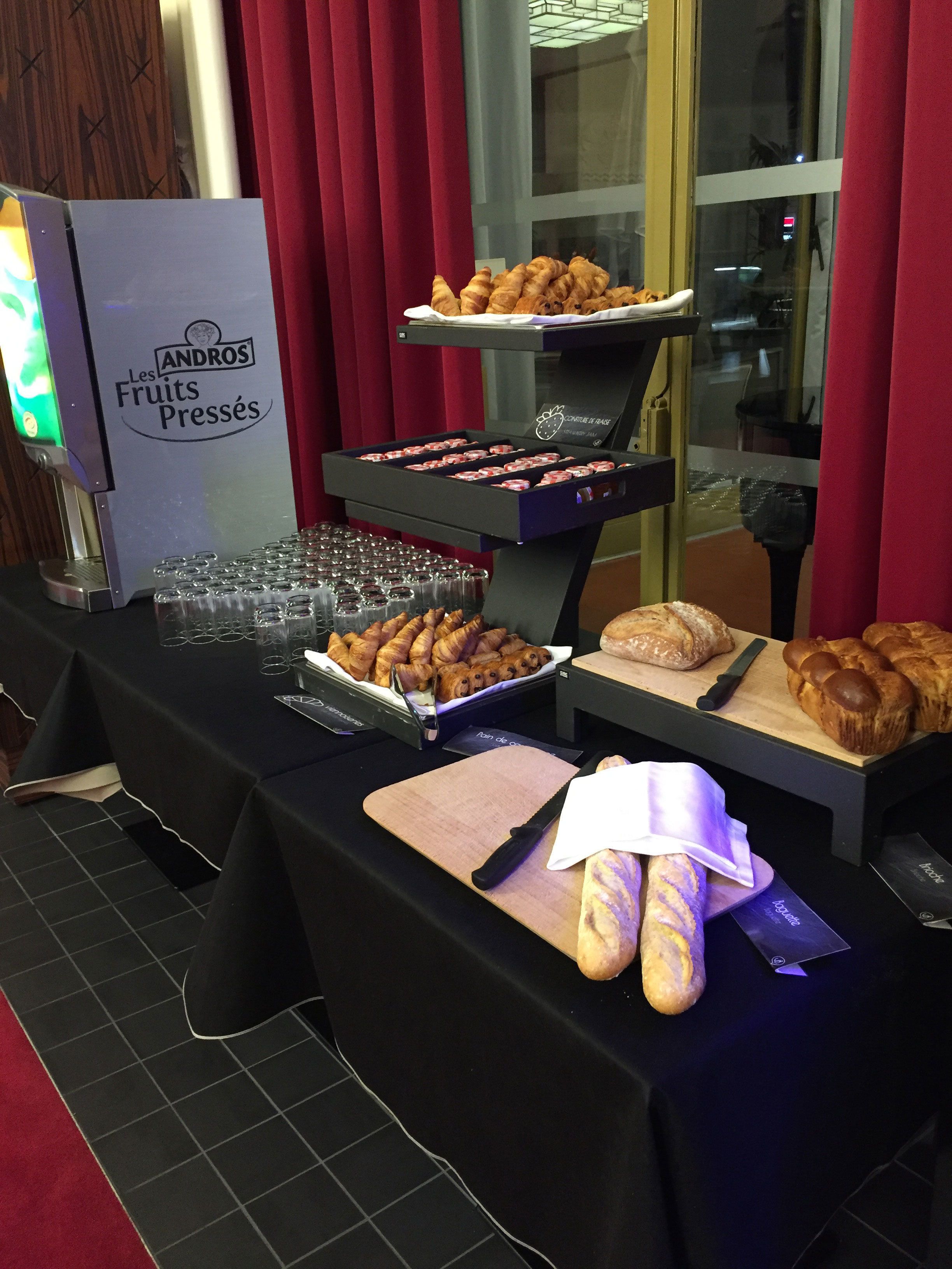 Une table de buffet proposant diverses pâtisseries et un coin boissons.