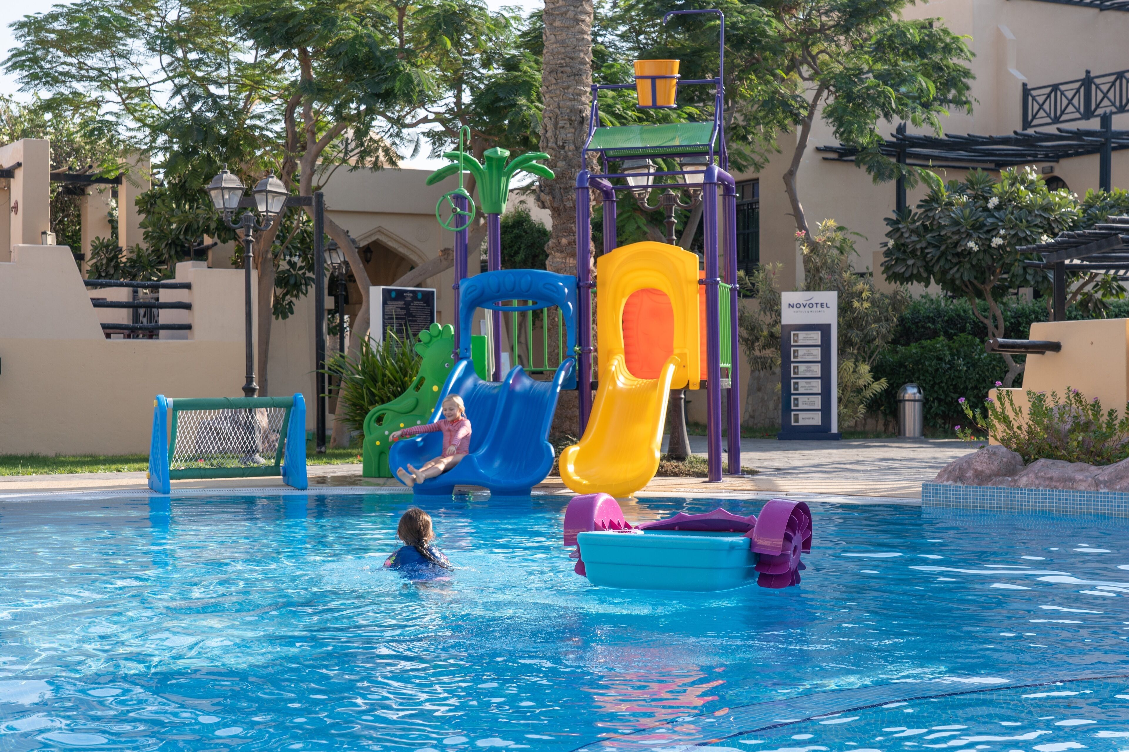A swimming pool with slides and a water play area.