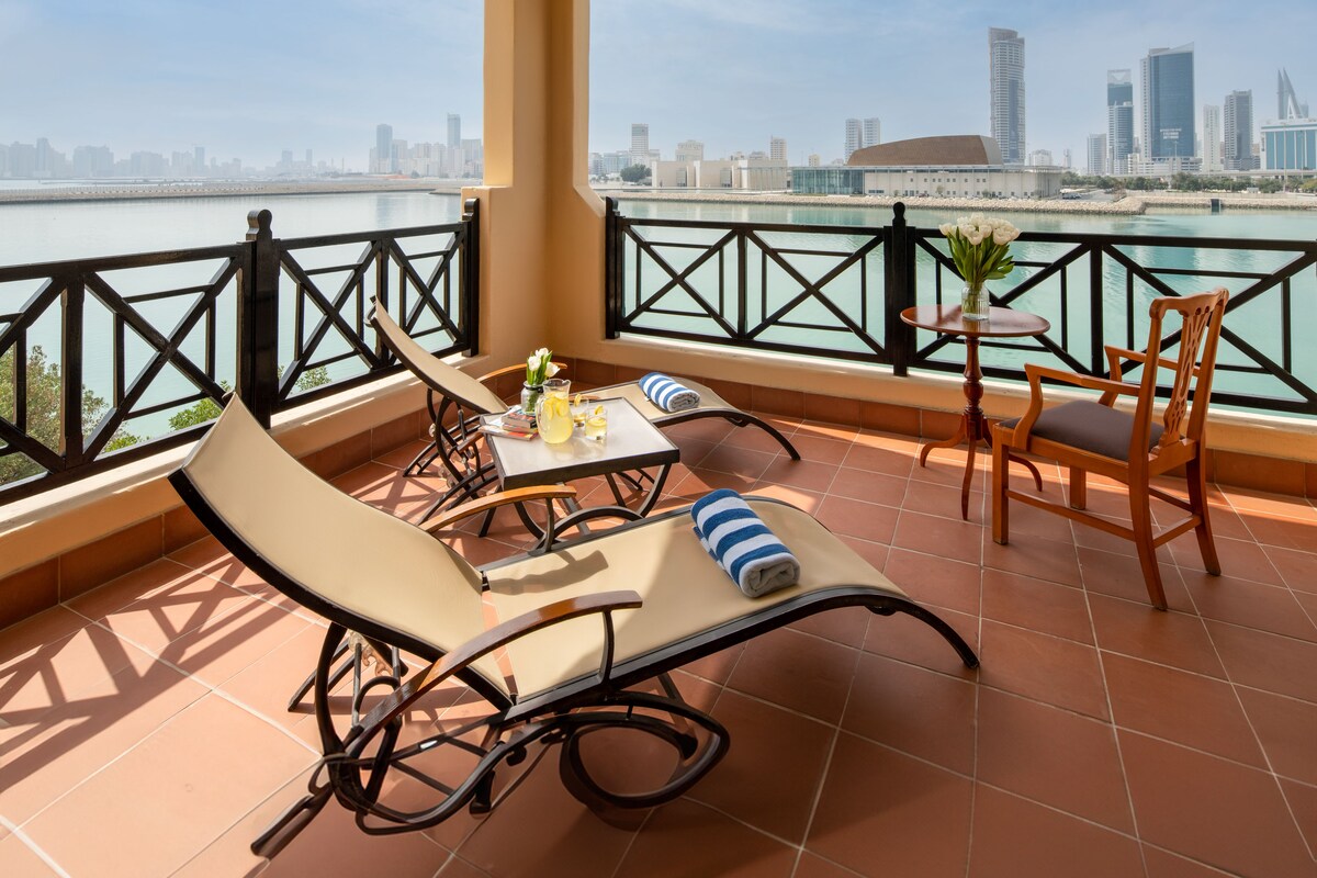 A terrace with a city view, including a body of water and a skyline.