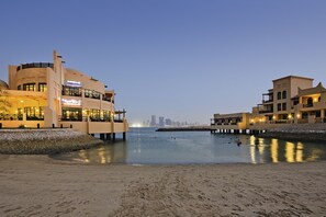 Private beach, sun loungers, beach umbrellas, beach towels - Novotel Bahrain Al Dana Resort (Manama)