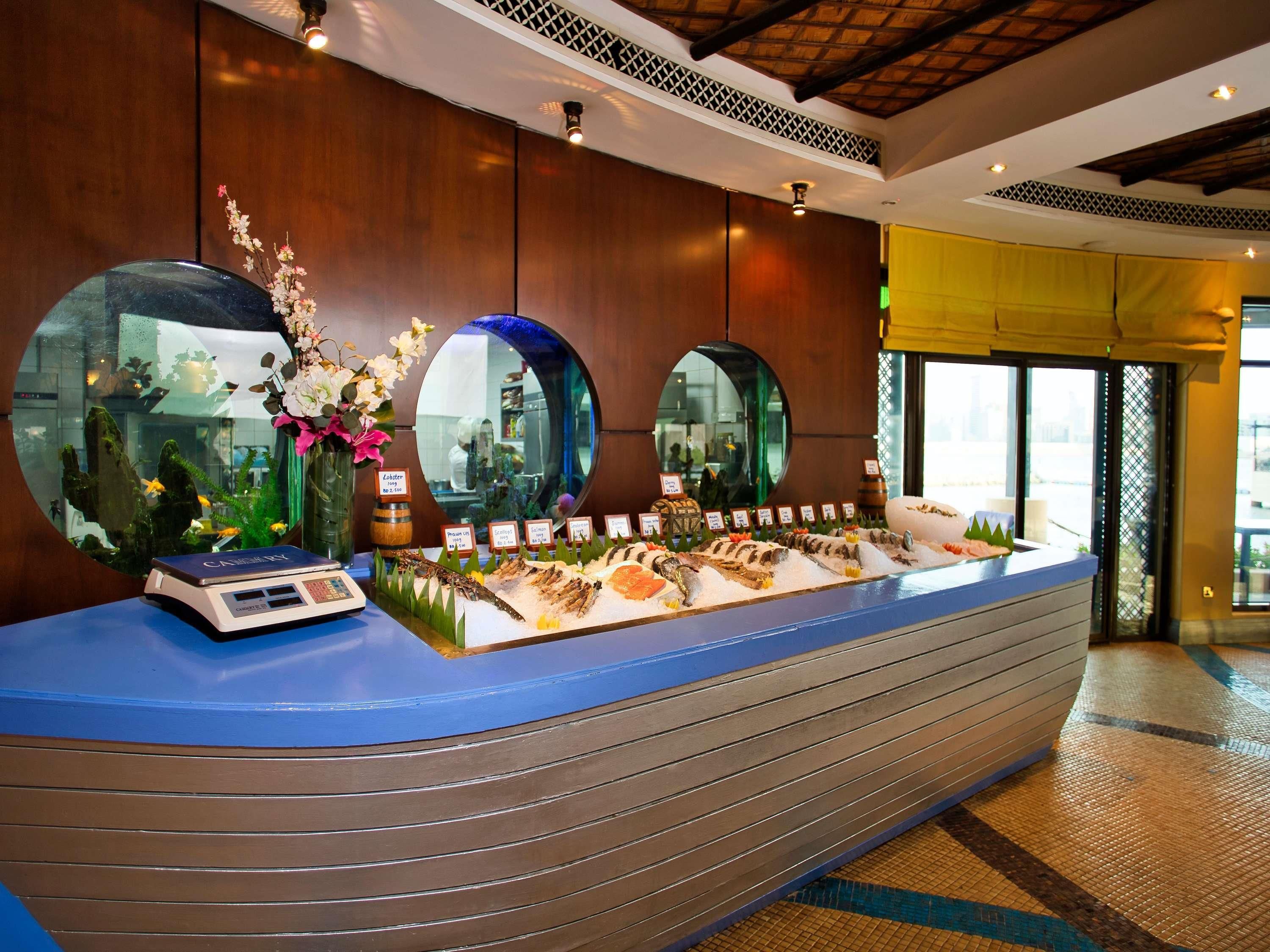 A reception desk with a scale, a mirror, and a display of seafood.