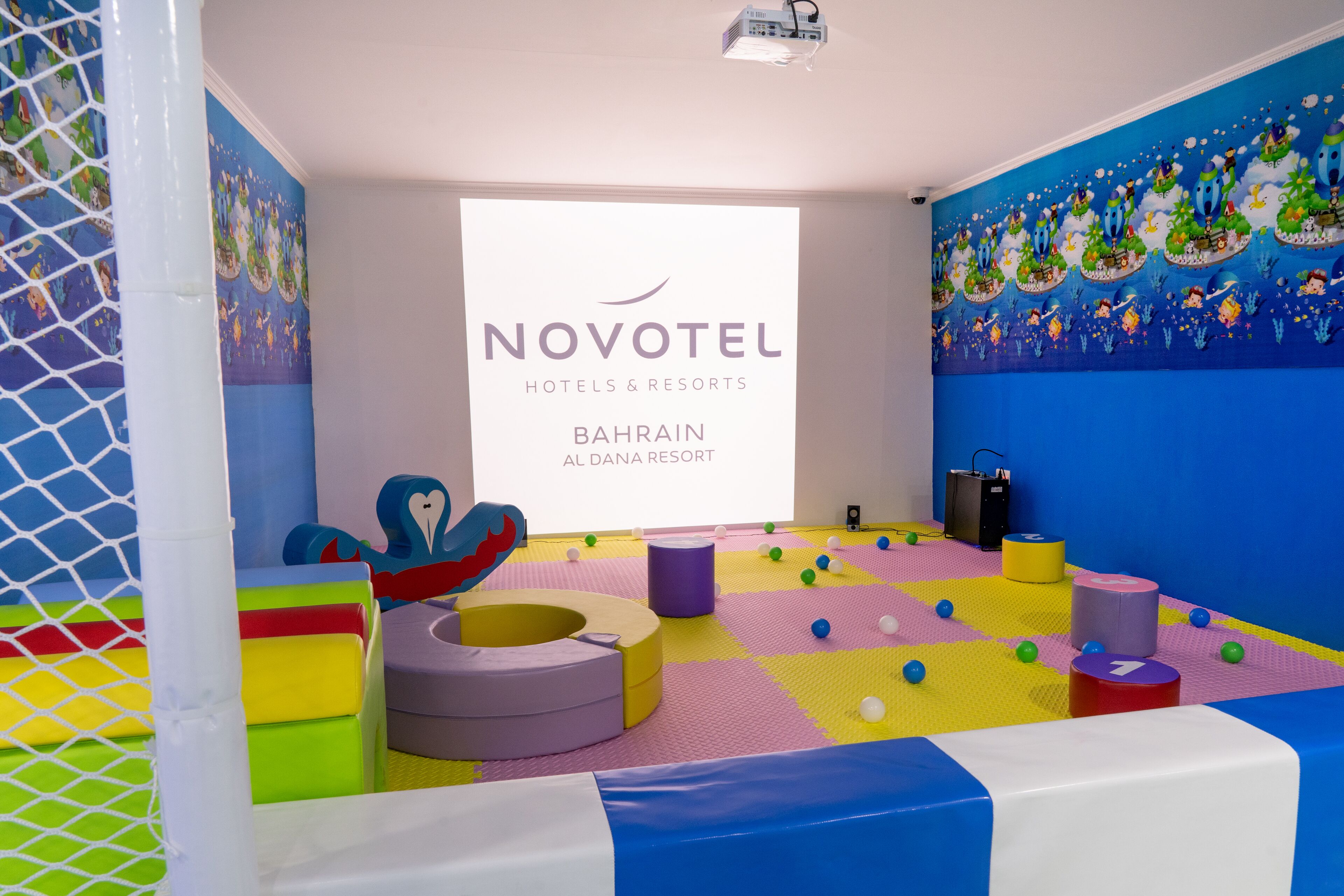 Un'area giochi colorata con un grande cartello NOVOTEL sullo sfondo.