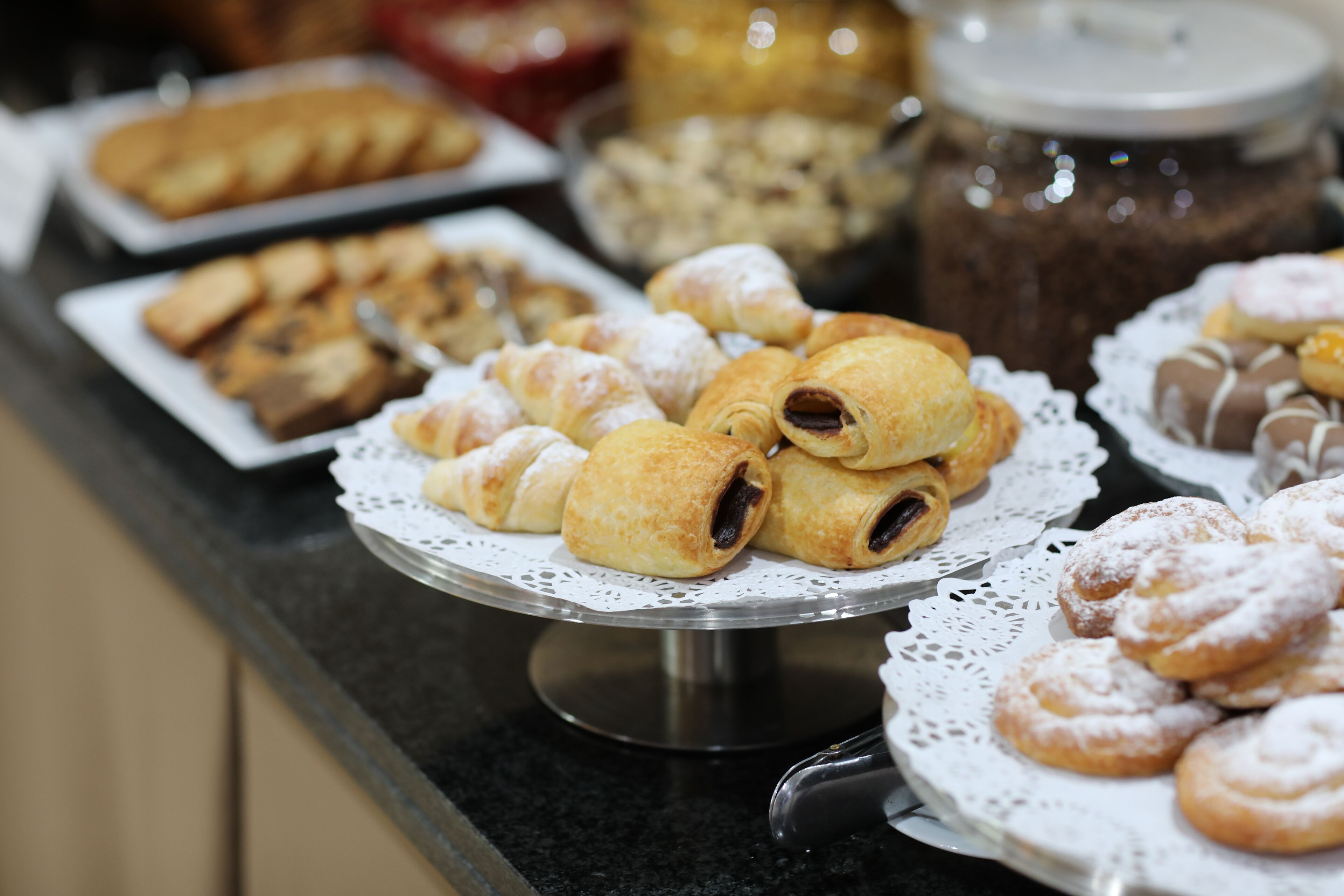 A buffet with various pastries and desserts on display.
