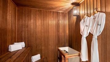 Relax in a serene sauna room with a wooden bench, table, and robes for a rejuvenating experience.