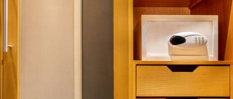 A microwave with a keypad in a wooden cabinet with drawers.