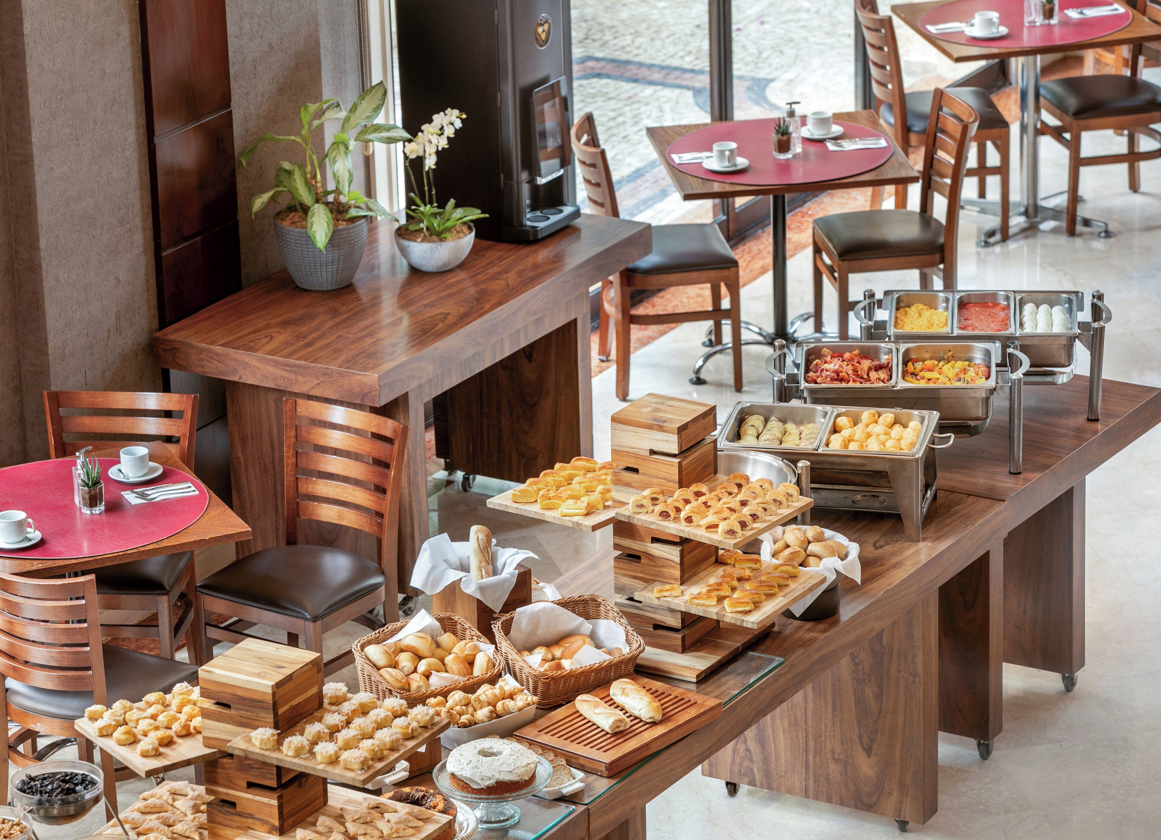 Disposição de buffet com diversos alimentos e organização de assentos.