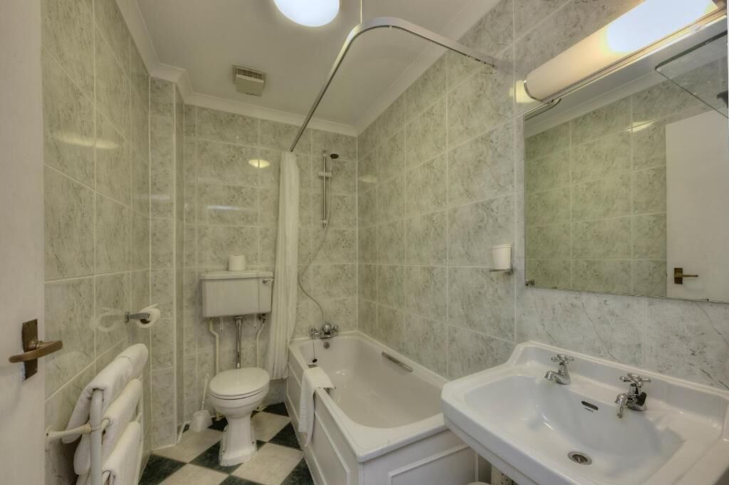 Un baño con bañera, lavamanos e inodoro.