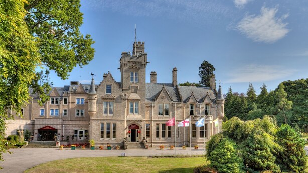 A large, historic building with a prominent tower, multiple windows, and a well-maintained lawn. - Muthu Newton Hotel (Near Inverness Airport) (Nairn)