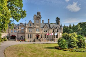 A large, historic building with a prominent tower, multiple windows, and a well-maintained lawn. - Muthu Newton Hotel (Near Inverness Airport) (Nairn)