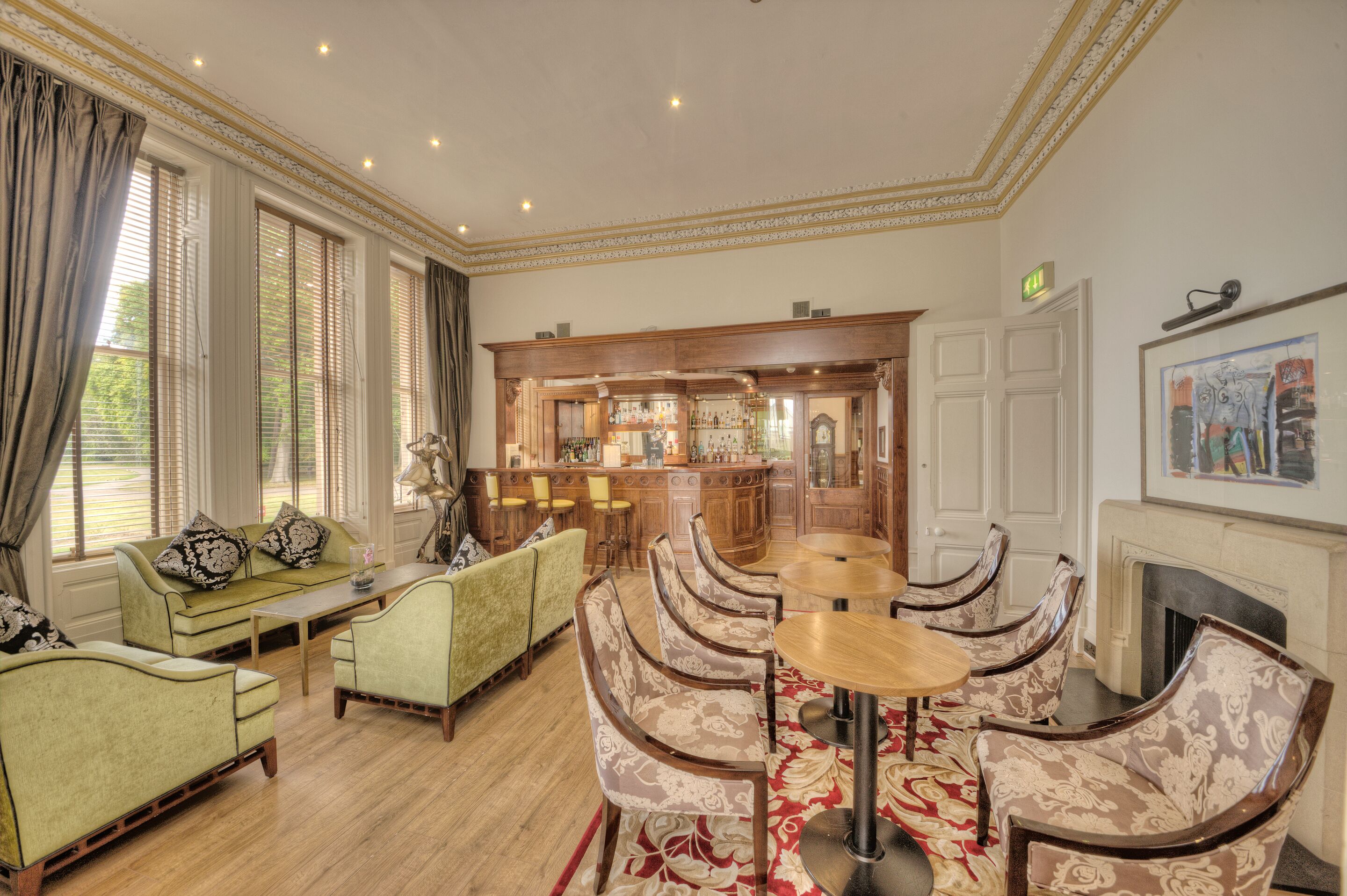 A spacious room with a bar area, seating arrangements, and a fireplace.