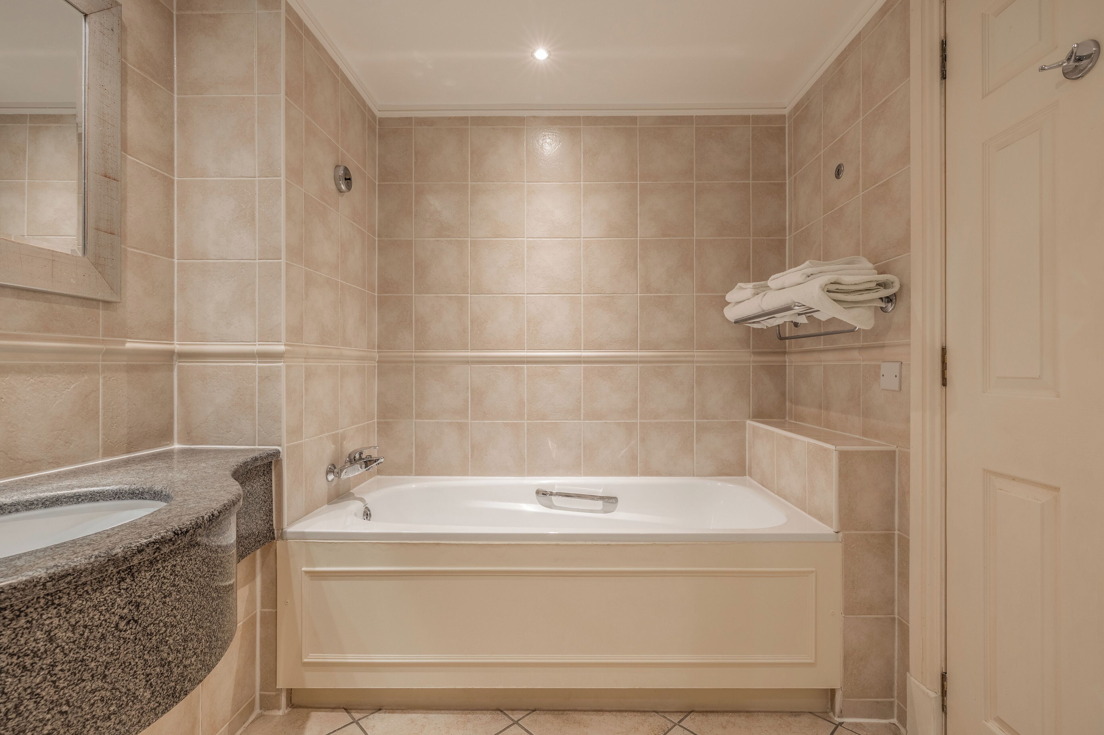 Un baño con bañera, lavamanos y espejo.