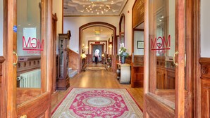 A hotel lobby with a grand wooden staircase, a central chandelier, and a patterned carpet. - Muthu Newton Hotel (Near Inverness Airport) (Nairn)