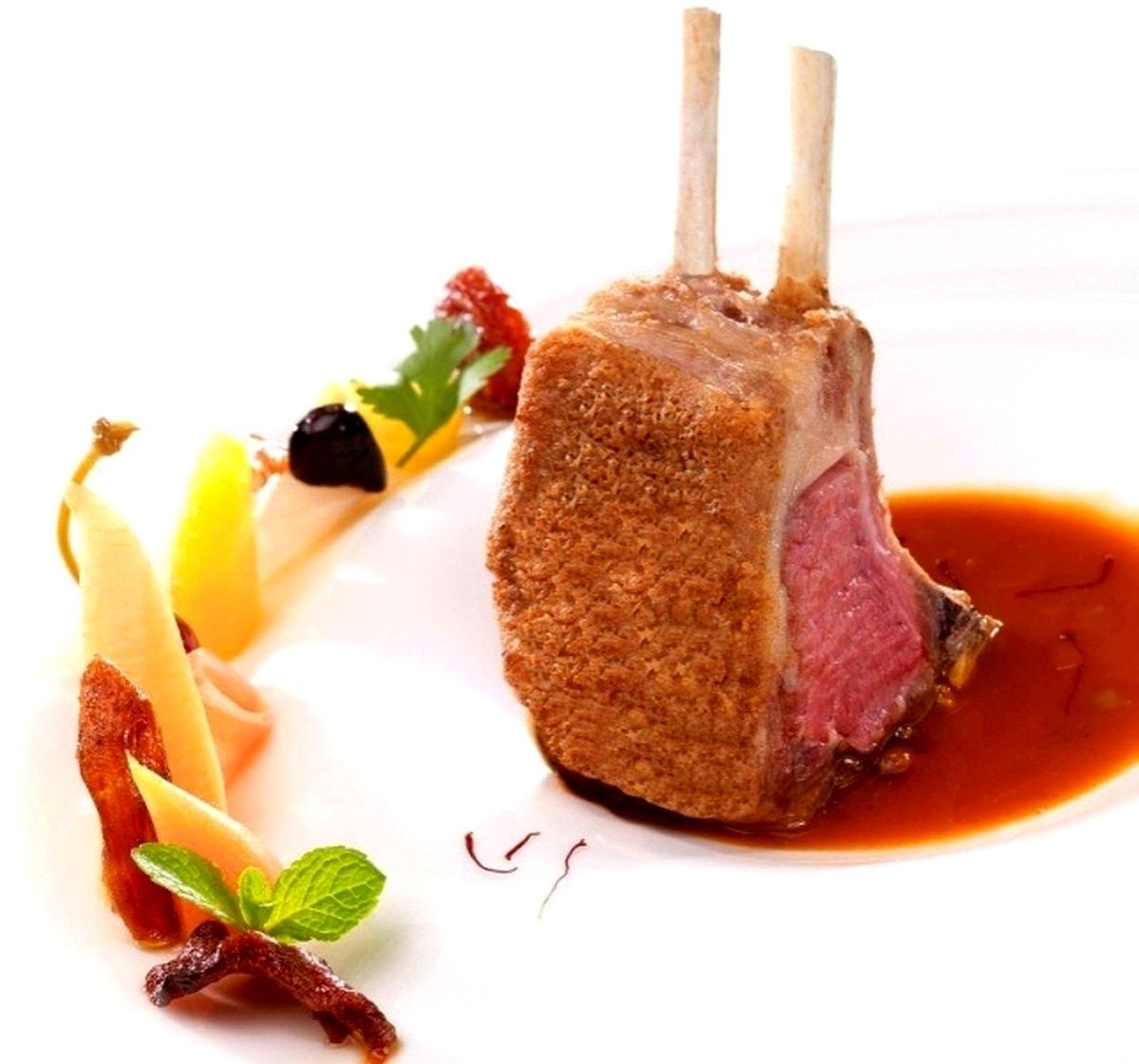 Un plat composé d’une côte d’agneau panée, accompagnée d’une sauce.