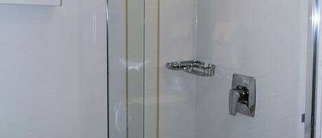 Un box de ducha moderno con puerta de cristal, cabezal de ducha de mano y panel de control.