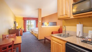 A hotel room with a kitchenette, a dining area, a bed, and a bathroom. - Holiday Inn Express & Suites Richland by IHG (Richland)