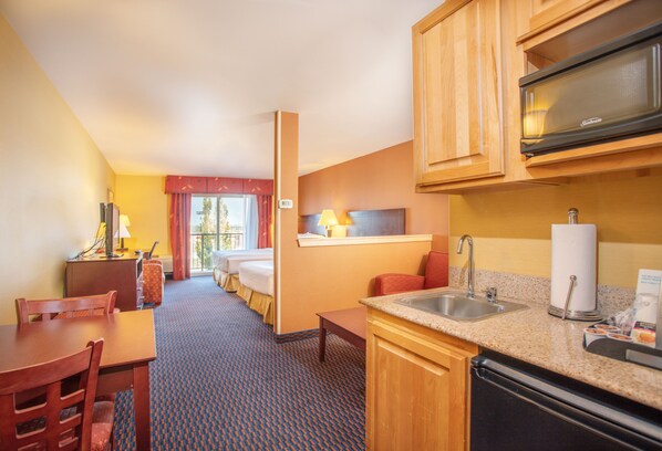 A hotel room with a kitchenette, a dining area, a bed, and a bathroom. - Holiday Inn Express & Suites Richland by IHG (Richland)