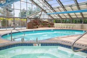 Piscine intérieure, piscine extérieure, parasols, chaises longues