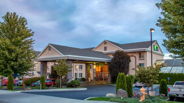 A hotel with a modern design, featuring a large entrance, a parking lot, and a well-maintained garden area. - Holiday Inn Express & Suites Richland by IHG (Richland)